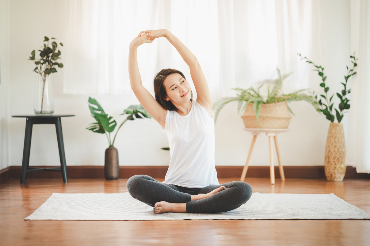 Asian Woman Doing Yoga Shoulder Stretching at Home